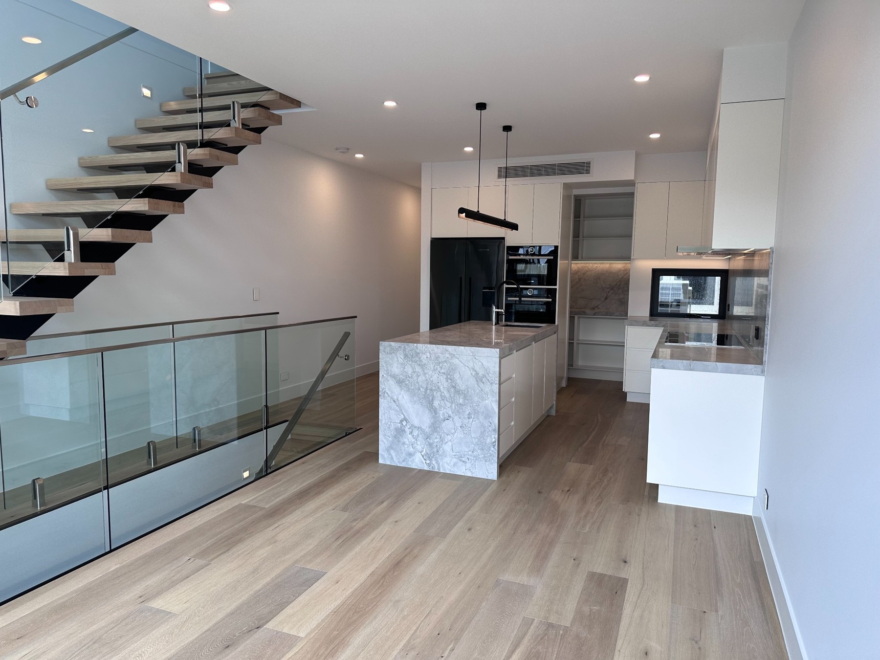 Bright Brunswick interior with an open staircase and white kitchen
