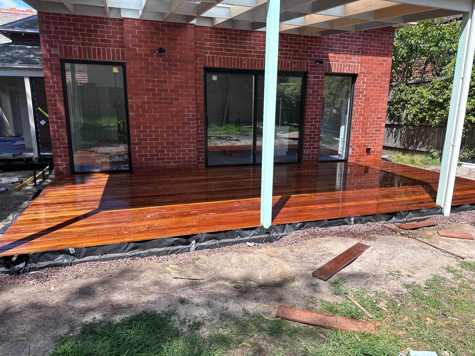 Timber deck outside a red brick home